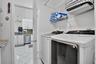 Dedicated laundry area featuring a washer and dryer, wire shelving, and tiled flooring