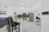 Kitchen featuring white cabinetry, stainless steel appliances, a counter-height breakfast bar, tile flooring, and recessed lighting