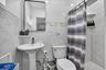 Pedestal sink, full wall tile surround, mosaic accent tile, built-in shower shelving, and a rectangular frameless mirror