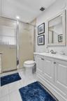 White vanity with cabinet storage, a top-set sink, and a framed mirror