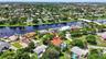Aerial perspective showcasing the property with a private pool, surrounded by lush landscaping and a developed residential area