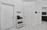 Light-toned tiled flooring, white walls, and bright white interior doors