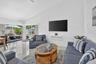 Vaulted ceiling, white tile flooring, ceiling fan, sliding glass doors, and a swimming pool