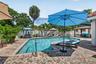 Swimming pool with curved edges, surrounded by a paver patio