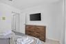 Wall-mounted television with a wood-finish dresser