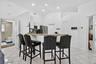 Kitchen with white cabinetry, stainless steel appliances, and a breakfast bar featuring a speckled countertop