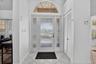 Entryway featuring a decorative arched transom window, frosted glass paneled door with side panels, louvered closet doors, and diagonal tile flooring