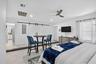 White walls with recessed lighting, tile flooring, barn door entry, ceiling fan, and a built-in media console