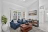 Bay windows with blinds, vaulted ceiling, tile flooring, and a ceiling fan