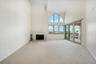 Spacious living room with soaring ceilings and fabulous natural light. Facing west, perfect for enjoying sunsets over the water.
