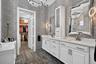 Primary Bathroom with Italian wallpaper, chandelier, double vanity with lots of storage. Also additional linen closet