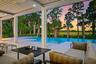 Covered outdoor living space featuring an infinity-edge pool, large format patio pavers, recessed lighting, and a ceiling fan