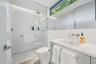Floating vanity with an integrated rectangular sink, wall-mounted faucet, and a large mirror
