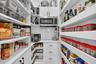Custom Walk in Pantry with appliance cabinet, pull out shelves, custom spice rack, microwave, electric and quartz countertops.