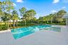 Resort-style saltwater swimming pool with sun shelf and integrated spa features, surrounded by expansive light-colored pavers