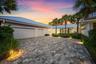 Modern exterior featuring a metal roof, two-car garage, and a paver driveway
