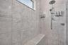 Large walk in shower with rain shower head and handle held.