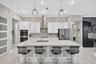 Custom Kitchen with island seating, designer pendant lighting, high end appliances, tile backsplash, double ovens.