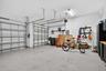 3 car garage with cabinetry, over head storage and finished floor.