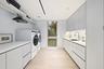 Integrated laundry appliances, extensive counter space, sleek cabinetry, recessed lighting, and wood-finish flooring