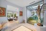 Bright, open interior showcasing light wood-finish flooring, recessed ceiling lighting, and large glass sliding doors framing landscape views