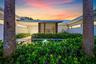 Modern exterior architecture with a flat roofline, horizontal slat detailing, and a reflective water feature