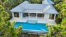 Modern architecture featuring a metal roof, expansive patio, and integrated swimming pool with a step entry