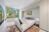 Expansive sliding glass doors, light wood-finish flooring, built-in cabinetry, integrated lighting, and integrated bedside tables