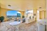 Large covered patio featuring a built-in outdoor kitchen with grills, and generous lounge area