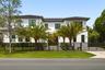 Modern two story residence framed by mature royal palms and manicured landscaping