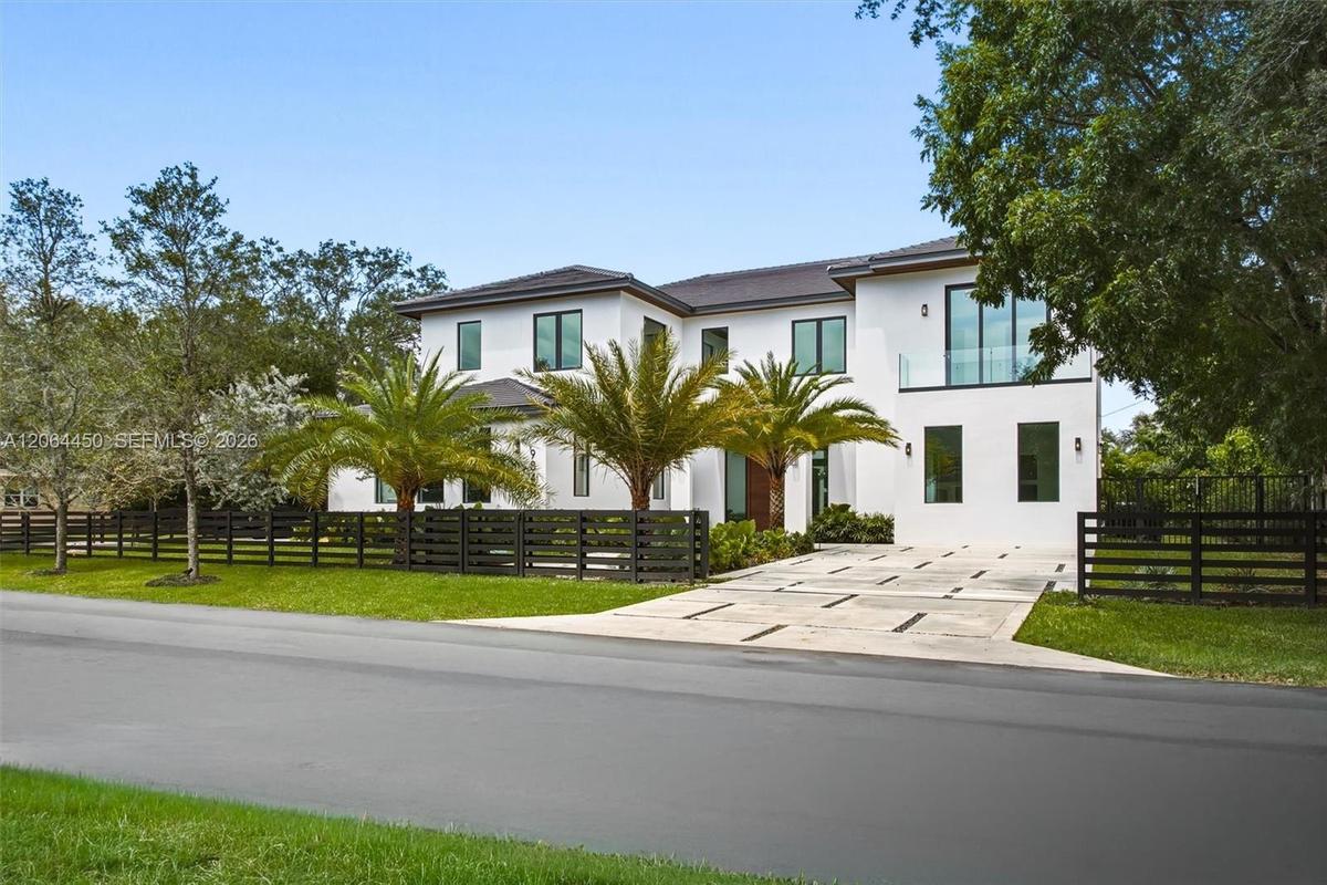 Welcoming entry walkway lined with lush tropical landscaping leading to the front door