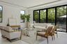 Great room facing the kitchen and bar seating under soaring ceilings