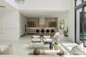 Double-height ceiling, glass-paneled staircase railing, built-in recessed lighting, recessed linear ceiling accents, and a wood-finish front door with