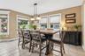 Dining Area Surrounded By Oversized Windows and Sliding Glass Doors
