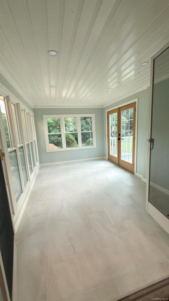 All season porch with radiant heated floors, open to dining room via double doors.