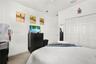 Tray ceiling, wood-finish flooring, recessed wall niche, and ceiling-mounted light fixture with fan