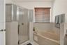 Neutral interior space featuring wood-finish flooring, a ceiling fan, a dual-panel closet, and a multi-pane door