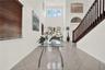 Kitchen featuring wood-finish cabinetry, central island with quartz countertop, tile flooring, recessed lighting, and stainless steel appliances