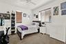 Bay area featuring three windows with wood-finish blinds, wood-finish flooring, and a six-panel door