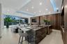 Open-concept kitchen and family room featuring a waterfall-edge natural-stone island, custom Italian cabinetry, architectural cove lighting, and unint