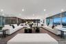 Expansive third-floor entertainment lounge with multiple conversation areas, contemporary designer furnishings, and seamless access to the covered ter