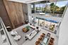 Second-floor view overlooking the dramatic two-story great room, infinity-edge pool, and waterfront beyond.