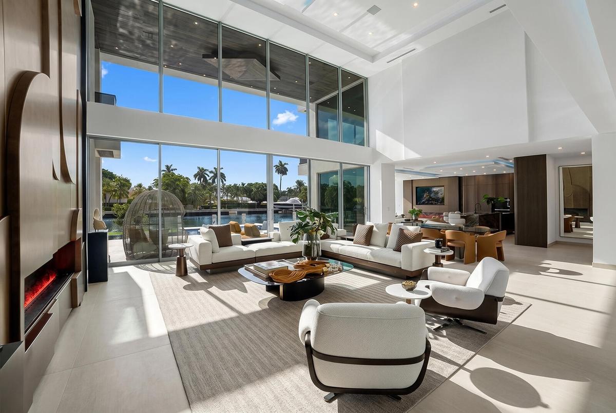 Expansive open-concept living space with soaring ceilings, walls of glass, custom architectural details, and effortless indoor-outdoor living.