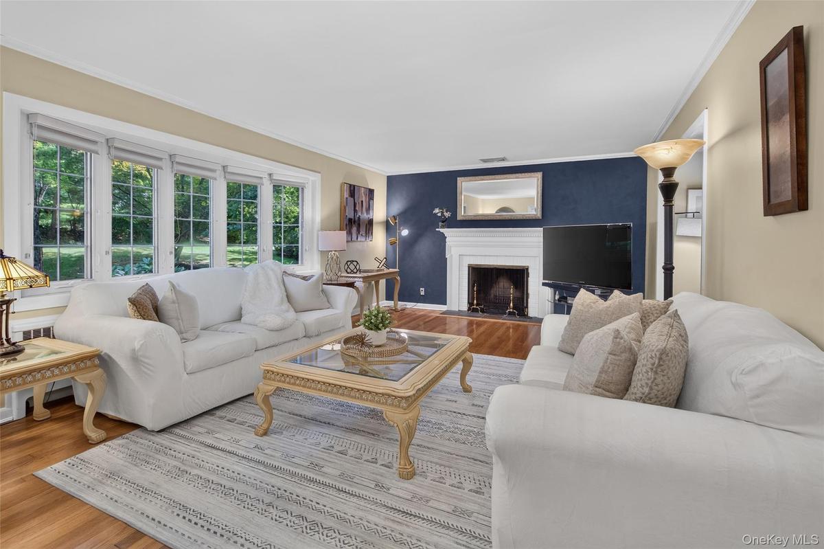 Large living room with bay window and wood buring fireplace