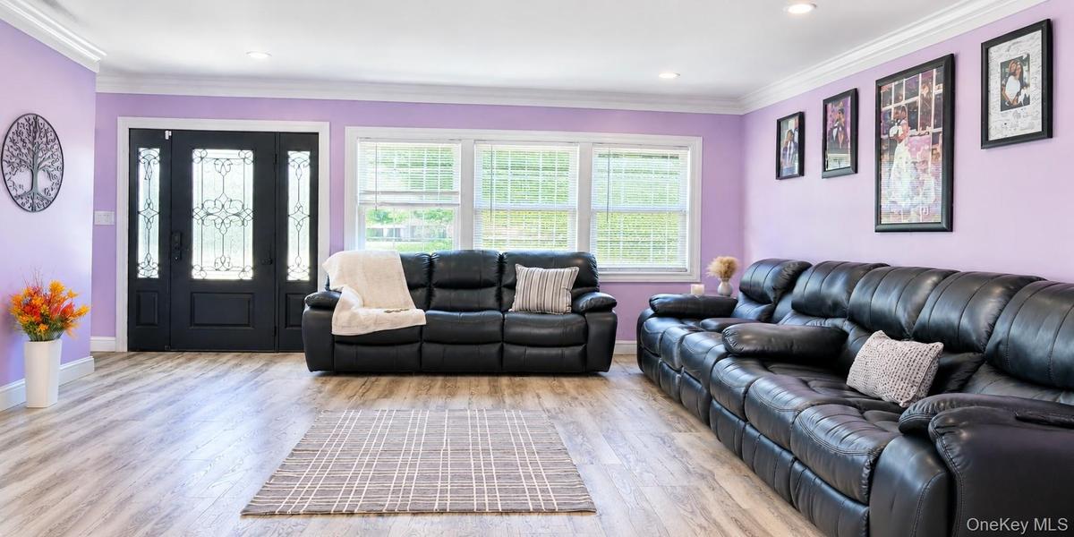 Wood tone -finish flooring, recessed lighting, crown molding, and a decorative front entry door with sidelights.