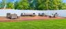 Expansive deck with a surrounding white privacy fence, featuring a lush green lawn and trees.