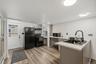 MAIN HOUSE - Kitchen featuring an island with sink, extensive counter space and direct exterior access.