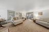 MAIN HOUSE - Spacious living room with multiple windows and a wide opening to the entrance hall.