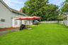 Spacious fenced backyard with multiple outdoor seating areas.