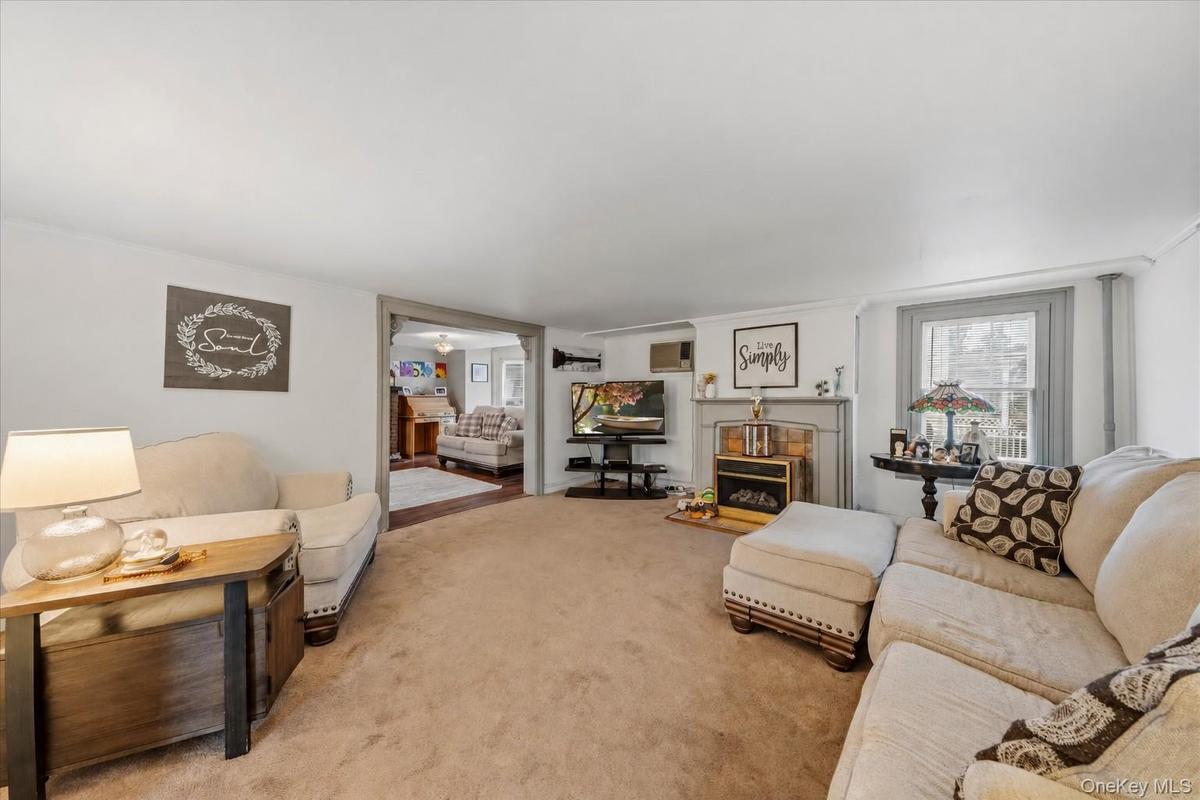 MAIN HOUSE - Additional view of the living room, featuring a fireplace and access to the adjoining room.